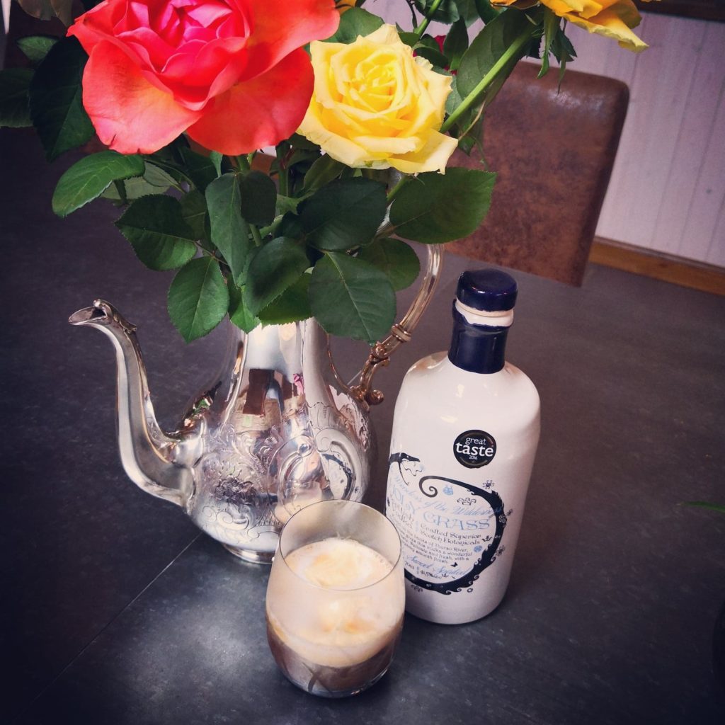 Bottle of Holy Grass Vodka and Holy Highland Coffee cocktail served in a tumbler glass