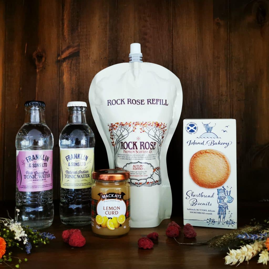 Content of the Refill Refill Rewards Club box for September 2021 including Rock Rose Gin pouch, ginger ale, lemonade, shortbread biscuits and lemon curd jar