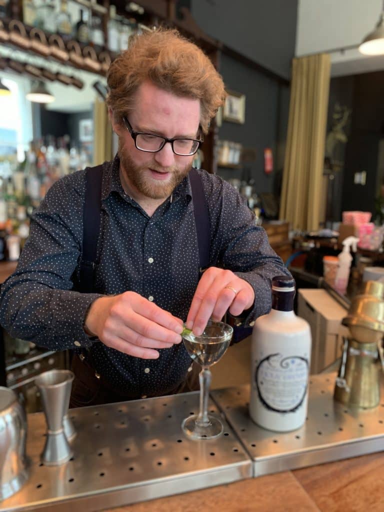 Picture of Kit Stutt owner of The Clockwork Rose bar preparing a cocktail with Holy Grass Vodka