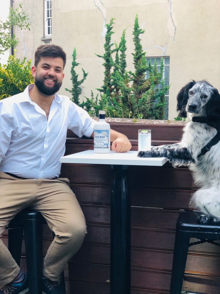 Max Haward and his friend Freddie sitting at table with a bottle of Rock Rose Gin