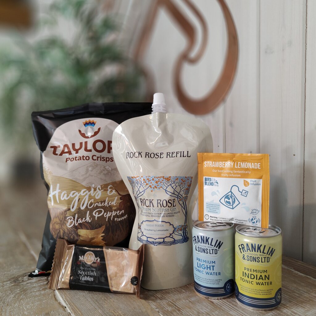 Content of Refill Rewards box in June 2024 including Taylors Potato Crisps, Rock Rose Gin pouch, Fruit infusion, two cans of tonic water and Scottish Tablet